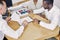 Black clients sign a contract while sitting at table with salesman