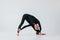 In black clothes. Young woman in sportive clothes doing gymnastics indoors