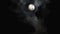 Black clouds passing in front of the moon in the night sky. Outdoor at nighttime.