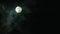 Black clouds passing in front of the moon in the night sky. Outdoor at nighttime.