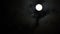 Black clouds passing in front of the moon in the night sky. Outdoor at nighttime.