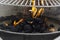 Black coal briquettes on fire under bbq mesh