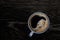 Black coffee in a blue-grey ceramic mug isolated on dark brown wood table with grain from above. Space for text