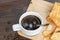 Black coffee,cracker and coffee bean on wood with warm morning