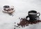 Black coffee cup with saucer and doughnut with black cookies on stone kitchen table background. Space for text. Breakfast snack. F