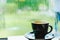 Black coffee cup on table in cafe restaurant near window in garden when raining in garden outside shop,Food and drink