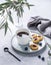 Black coffee espresso in a cup with homemade berry cookies and blueberries on a light background with eucalyptus branches