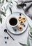 Black coffee espresso in a cup with homemade berry cookies and blueberries on a light background with eucalyptus branches