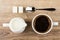 Black coffee, jug of milk, lumpy sugar and spoon