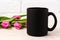 Black coffee mug mockup with magenta pink tulips bouquet