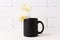 Black coffee mug mockup with soft yellow orchid