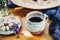 Black coffee in a stoneware cup at home with a bouquet of country flowers