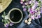 Black coffee in a stoneware cup at home with a bouquet of country flowers