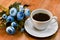 Black coffee in white cup with blue flowers on wooden table.Cosy