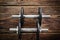 Black collapsible dumbbells on wooden background