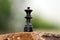 Black color Wooden Queen Chess piece put on a stone