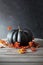 Black colored pumpkin with berries and leaves