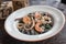 Black Conchiglie Pasta Shells with Seafood and Spinach. Modern Cafe Lunch