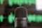 Black condenser microphone, mike blur green waveform background