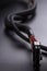 Black connector and Cable with snake skin. Black braided wires in bundle on black background. Data line protection. Wire Flame-