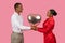 Black couple holding heart-shaped balloon, sharing moment