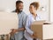 Black Couple Holding Moving Boxes Standing Back-To-Back In New Home