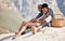 Black couple, picnic and love with a smile on a rock with South Africa blurred mountain background. Relax, man and woman