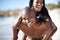 Black couple, smiling and piggyback with portrait, beach and married for summer vacation. African, enjoying and happy