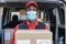 Black courier man delivering package in front of cargo truck wearing safety mask - Focus on face