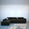 Black cozy sofa in modern interior room with hardwood flooring.