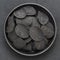 Black Crispy potato chips in bowl on dark background, top view