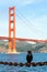 Black crow sits on rusted chain in front of Golden Gate bridge