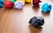 Black crumpled paper ball on dark brown wood table with group of