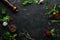 Black culinary background with spices and vegetables on the table. Top view.