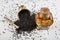 Black cumin seeds in bowl and essential oil in glass bottle. Nigella sativa isolated on white background