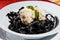 Black Cuttlefish ink Pasta with nuts balls and fresh mint. Closeup.