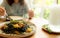 Black cuttlefish ink spaghetti with shrimp on plate. Black pasta with squid ink on a restaurant table and blur woman eating with