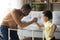 Black dad and little son have fun arm wrestling