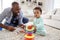 Black dad and toddler son playing on floor at home, close up