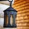 Black decorative antique forged metal lantern on an iron hook. A