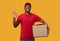 Black delivery man holding cardboard box showing okay gesture