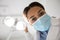 Black Dentist Lady Turning Lamp Before Check Up With Patient, Low Angle