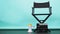 BLACK director chair with megaphone and Clapperboard or movie Clapper board on green or Tiffany Blue and black floor background.it