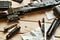 Black disassembled shotgun and cleaning tools on wooden table .