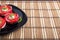 Black dish with sliced tomatoes and lettuce decorated with onion