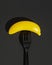 A black disposable plastic fork with a plastic banana impaled on it. The concept of ecological payback for excessive use of plasti
