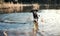 A black dog outdoors running in a lake.