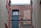 Black Door Beside a Bricked Over Window in an Alleyway