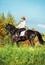 Black dressage horse with rider in autumn field