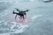 Black drone helicopter sits in standby on frozen lake